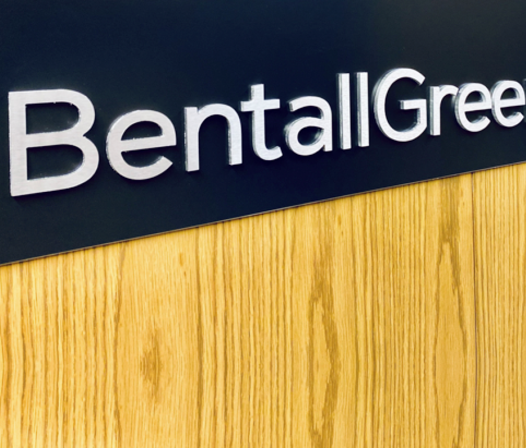 a wooden wall with the BentallGreenOak logotype on a blue background