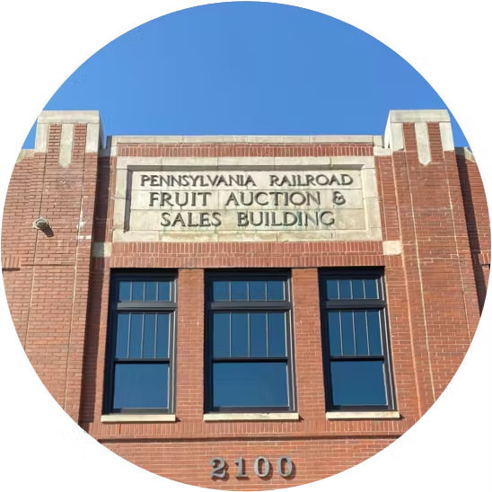 the front of the building on 2100 Smallman Street, with a large sign reading "Pennsylvania Railroad Fruit Auction & Sales Building"