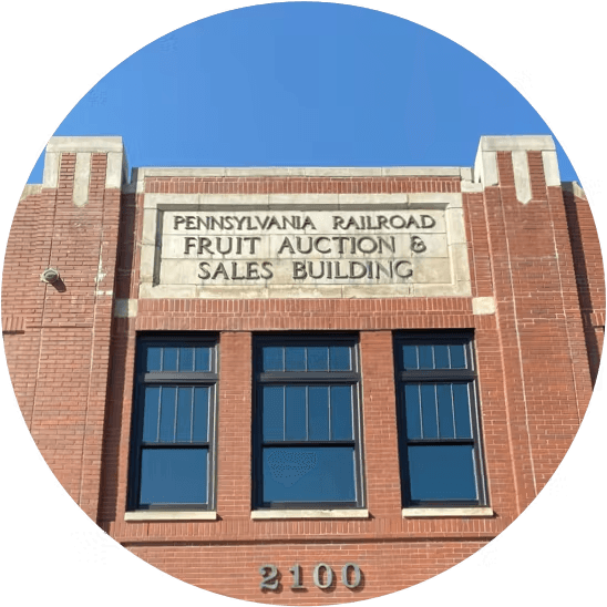 the front of the building on 2100 Smallman Street, with a large sign reading "Pennsylvania Railroad Fruit Auction & Sales Building"